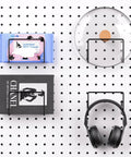 Slick Shop Pegboard Organizer And Hook Lock Kit With Heavy Duty Storage Bins displaying headphones, book, and wet towel on a pegboard.