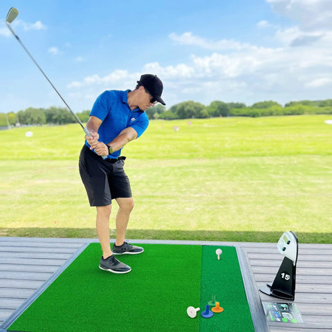 Golfer practicing with Golf Rubber Tees Practice Set With Mixed Size Tees in 5 colors on outdoor mat, showing swing setup.