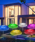 Solar Jellyfish Garden Lights 6 Pack Waterproof Outdoor Pathway Lawn Decor With 7 Color Changing Optical Fiber Bodies glowing in a yard