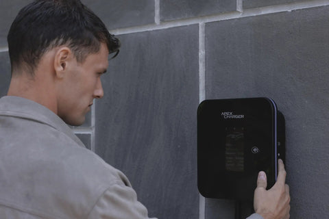 User interacting with Heavy Duty Level 2 Ev Charger With Tesla Nacs Plug 48 Amp Wall Mount Charging Station on wall.