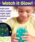 Totally Glowing Axolotl Aquarium Craft Kit For Kids Ages 6 And Up With Five Mini Axolotls, Glow In The Dark Decor, And STEM Fun, Hands On Arts And Science Gift For Girls And Boys; girl holds glow aquarium jar
