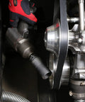Mechanic using Heavy Duty 19mm Crank Bolt Socket for harmonic balancer removal, with 1/2 inch drive impact wrench on engine.