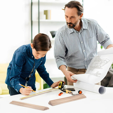 Father and son working on a craft project with a plan, using High Quality Game Changer Birch Dowel Rods For Craft Setup And Tiered Display 3/16 Inch X 15 Inch Pack Of Fifty Smooth Wood Sticks Perfect For Macrame Creations And Weekend Builds.