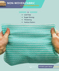 Hands holding green Heavy Duty Reusable Cleaning Cloths 50 Pack 11.8 By 15.7 Inches; non-woven fabric, texture visible