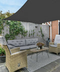Outdoor Shade Sail Rectangle 10 ft by 13 ft UV Block Canopy over a patio seating area, graphite color, easy setup.