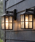 Black Outdoor Wall Lights Set Waterproof Patio Sconces Crafted From Rust Resistant Die Cast Metal And Tempered Wave Glass Ideal For Backyards And Entryways Sleek Modern Build That Braces Against Snow And Rain Hella Tough Construction Set Of Two illuminated in the rain.