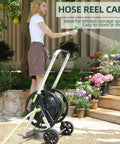 Woman using All Weather Garden Hose Reel Cart With Wheels Holds Seventy Five To One Hundred Fifty Feet Of Five Eighths Inch Hose