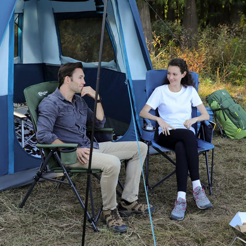 Two adults sitting outside a tent, one in an oversized folding high back lawn chair for adults with cup holder, carrying strap, hard armrests, 400lb capacity, blue, ideal for camping, fishing, hunting, sports, and backyard; blue chair visible