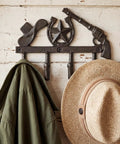 Straight Up Rustic Western Cast Iron Cowboy Coat Wall Mount Hook Featuring Authentic Horse Shoe Shape Perfect For Farmhouse Entryway Storage Built Tough As Nails Great For Holding Hats Keys And Bags Daily with green jacket and straw hat.