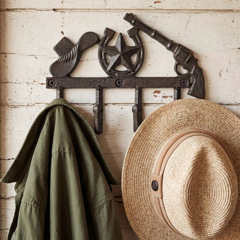Straight Up Rustic Western Cast Iron Cowboy Coat Wall Mount Hook Featuring Authentic Horse Shoe Shape Perfect For Farmhouse Entryway Storage Built Tough As Nails Great For Holding Hats Keys And Bags Daily with green jacket and straw hat.