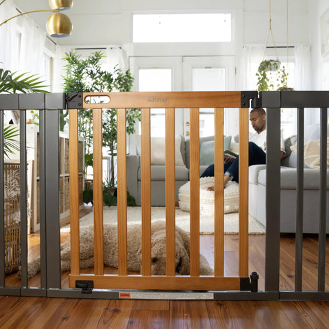 Living room view of Oak Wood And Metal Baby And Pet Gate For 36 To 60 Inch Openings, 30 Inch Tall, auto close feature.