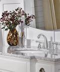Elmhurst Two Handle Widespread Bath Faucet Chrome Finish with ADA Compliant Push Pop Up Drain on white marble vanity
