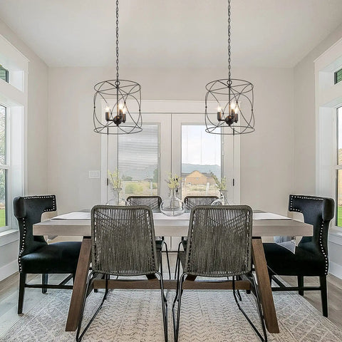 Dining room with Go-To Industrial Farmhouse Pendant Light for Kitchen Island and Dining Room, Black Cylinder Foyer Pendant Fixture With 13 Inch Diameter and Three Candle Socket Cage hanging above table.