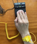 Person using Essential Anti Static ESD Wrist Strap Tester FEITA 498 with banana jack, showing grounded wristband in action