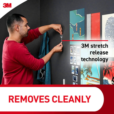 Man using Clear Medium Wall Hooks Set, 12 Hooks With 24 Adhesive Strips, Each Holds Up To 2 Pounds, damage-free hanging on wall