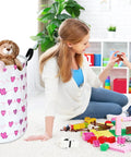 Round Laundry Basket Storage Bin For Home And Nursery beside mother and child playing with toy blocks in playroom