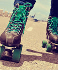 Close-up of quad skates on a road, highlighting PU toe stops from 5 Piece Roller Skate Toe Stop Set With 1 Pair Of Toe Stops For Quad Skates.