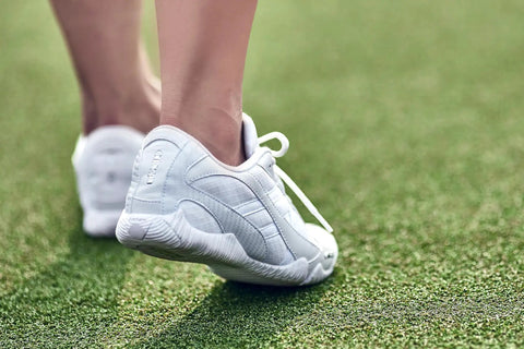 Stellarlyte Women's Cheer Shoe White Size 8.5 for Competition on grass, showing back view with flexible outsole
