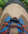Close-up of brown hiking boot laces with small black toggle on top.