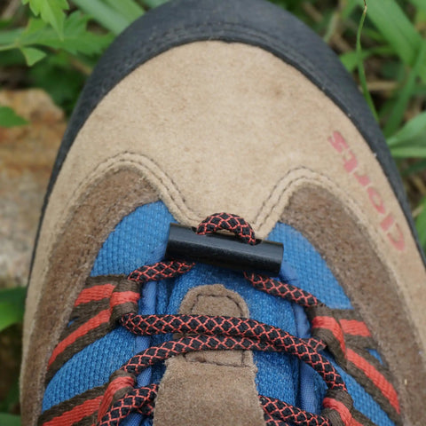 Close-up of brown hiking boot laces with small black toggle on top.