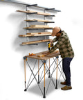 Worker using a drill next to a Six Level Wall Mounted Metal Lumber Rack For Garage Organization And Heavy Duty Wood Storage Shelf Pipe Holder Plywood Sheet Stand Optimizing Your Workspace In A Flash.