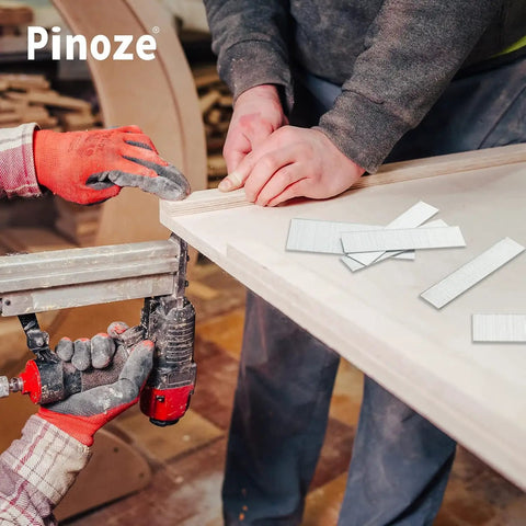 Worker using a pneumatic nail gun with Straight Shooter 18 Gauge Brad Nails Assorted 1300 Count Galvanized Steel for woodworking.