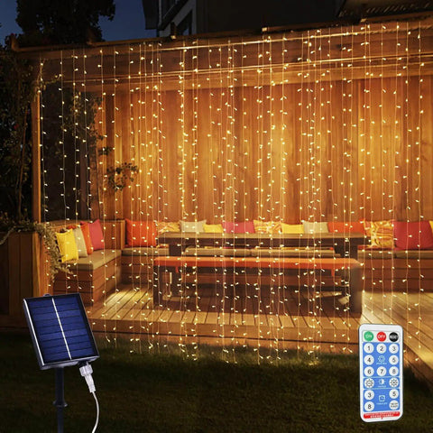 Solar Curtain Lights 300 LED Fairy String Lights With USB and Solar Dual Power lighting up a patio with cushions at night