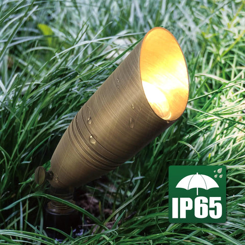 Outdoor view of a brass spotlight from the 12 Pack Solid Brass Landscape Spotlight Kit 12V AC DC Low Voltage Outdoor Uplight With ABS Ground Spike Waterproof Directional LED Fixture MR16 Bulb Not Included.
