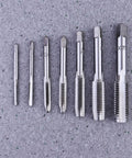 7 Piece Steel Screw Tap Set For Metalworking And DIY Projects, Heavy Duty HSS Taps To Repair Damaged Threads And Cut New Threads In Metal, Plastic And Wood, All In One Tapping Tool Kit With Multiple Size Taps. Seven steel tap sizes on gray surface
