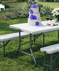 6 Foot Folding Table And Two Benches Outdoor Indoor Picnic Set Built Tough Durable Plastic With Space Saving Design For Quick Party Ready Storage And Transport Seats 6 To 8 People shown with cake and flowers