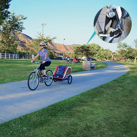 Person cycling in park with bike trailer hitch connector and cycling adapter for kids trailers, cargo, and pet trailers, close-up view.