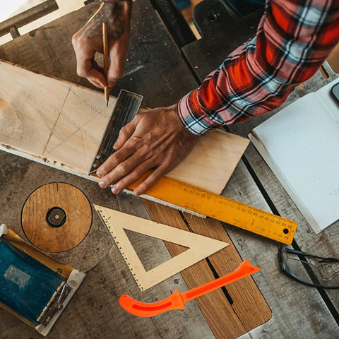 Woodworker using table saw safety push block and push stick set with orange polypropylene handle, measuring and marking a board.