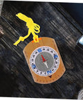 Adventure Ready Outdoor Precision Compass with safety lanyard, ruler, and luminous north pointer on a rustic wooden table.