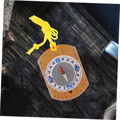 Adventure Ready Outdoor Precision Compass with safety lanyard, ruler, and luminous north pointer on a rustic wooden table.