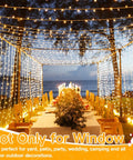 Christmas Curtain Lights 300 LED 9.8 By 9.8 Feet Waterproof Outdoor Curtain String Lights decorate a beachside dinner setup.