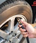 No Sweat Quarter Inch Tire Inflator Extension Hose With Fast Grip Self Locking Chuck inflating a car tire at a gas station.