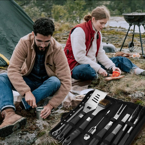 Camping scene with couple using 15 Piece Heavy Duty Stainless Steel Grill Tool Set With Long Sixteen And A Half Inch Spatula, Fork, Tongs.
