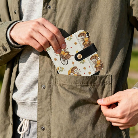 Person inserting Totally Clutch Vintage Rickshaw Bifold Wallet For Women Featuring Autumn Leaves Motif into jacket pocket.