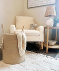 Tall Woven Laundry Basket for Living Room and Bedroom, Boho Farmhouse Round Wicker Blanket Basket next to a chair and table