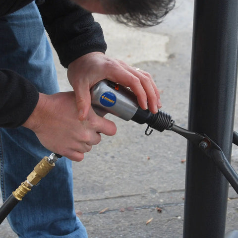 Person using ATK1002 50 Piece Ultimate Air Tool Kit With Bonus Inflation Tool For Home Garage And DIY Use on metal structure
