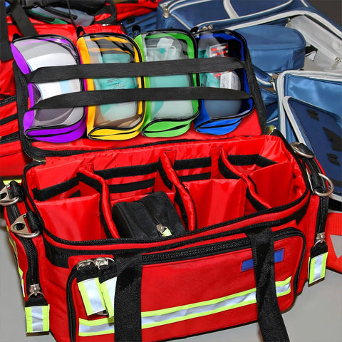 Front view of red first-aid bag opened to show eight color pouches with transparent windows and zipper compartments.