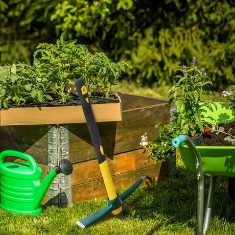 Four Pack 15 Inch Mattock Hoe With Steel Forged Pickaxe And Fiberglass Handle Built For Weeding Prospecting Camping And Hand Digging This All Purpose Workhorse Tool Set in garden next to plants and wheelbarrow