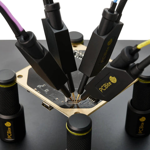 Four SQ10 digital probes with test wires on a PCB, for electronics prototyping and repairs, hands-free workbench tool.