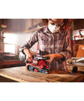 Person using Corded 7 Amp Belt Sander Workhorse With Angled 3 Inch By 21 Inch Belt For Closer Sanding in workshop