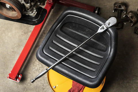 One Half Inch Drive 84 Tooth Locking Flex Head Teardrop Ratchet, 24 Inch Length, on black seat in garage workshop