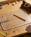 Premium Acrylic Two In One Cutting Board Router Template For Woodworking And Inlay Projects Laser Cut Quarter Inch Thick Guide on a workbench with wood shavings.