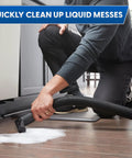 Heavy Duty 8 Gallon Wet Dry Shop Vac Delivering 75 Cfm Raw Heavy Lifting Suction For Serious Garage Cleanups Includes 17 Foot Extender Hose being used to clean liquid spills.