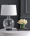 Clear Glass And Black Metal LED Table Lamp For Bedroom And Living Room on white table beside tulips and books