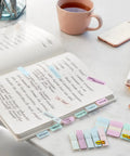 Sticky Tabs 2 In By 1.5 In Book Markers in Assorted Bright Colors for Reading, Annotation, Reminders, and Easy Organization on a desk with a notebook.