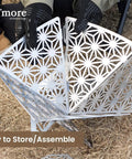 Portable Camping Fire Pit With Grill For Cooking being assembled, showcasing sturdy steel design with intricate cutout pattern.